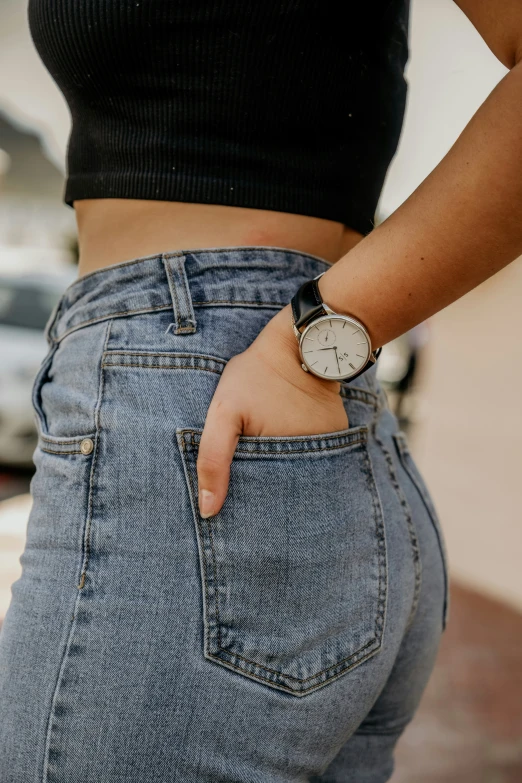 a woman's arm and chest are visible from her jeans
