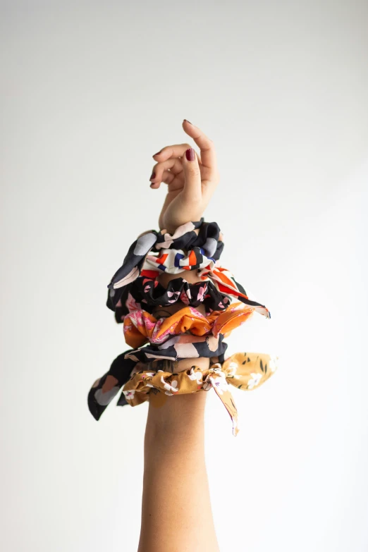 woman's hand holding multicolored scarfs in air