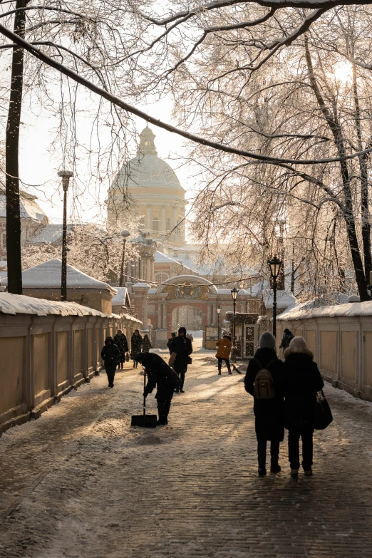 people are walking along a city park near the water