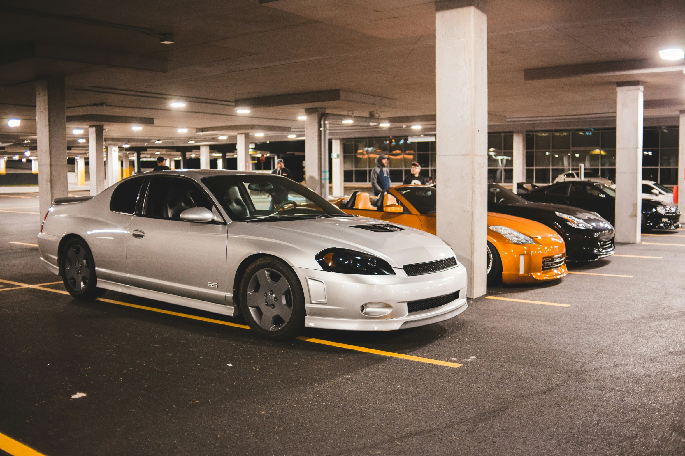 three sports cars are parked in a parking garage