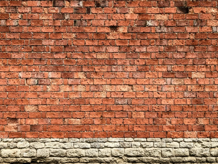 a large brick wall has a broken fire hydrant on the side