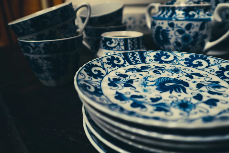 an assortment of blue and white cups and plates