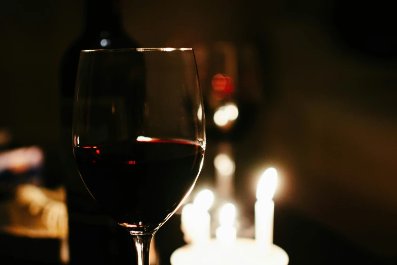 a wine glass is sitting next to candles