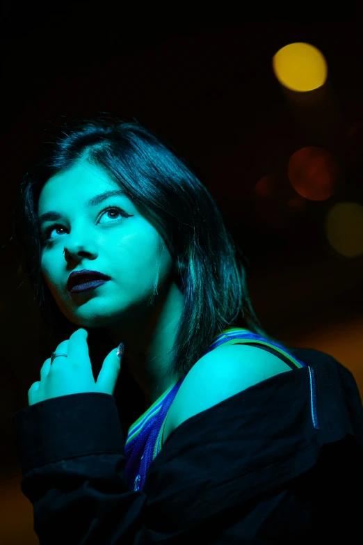 a woman in black standing with her hand on her chin