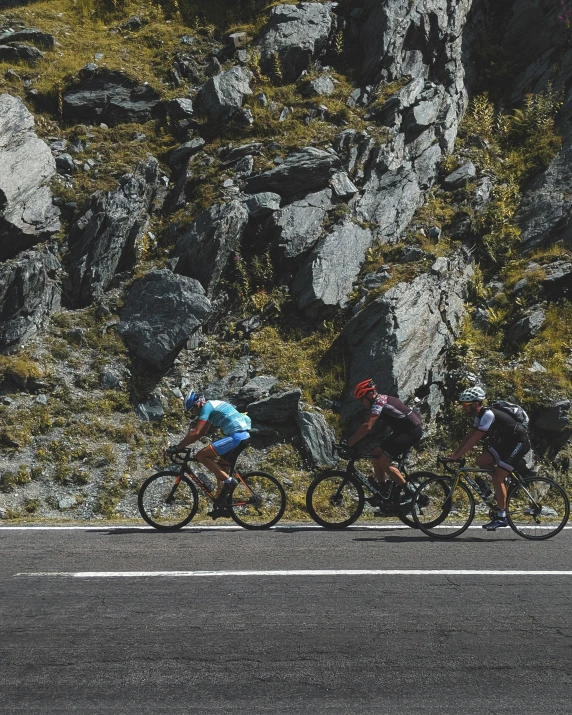 a group of people riding bikes near rocks