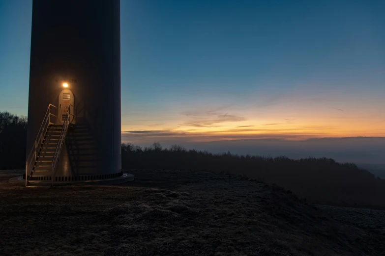 a windmill that is standing on some dirt