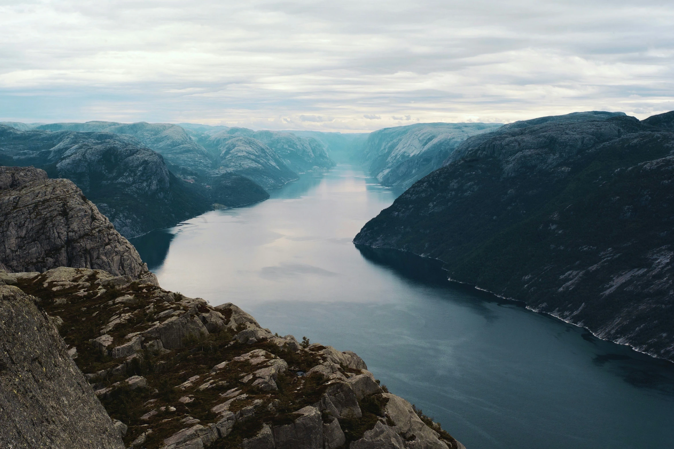 an aerial view of mountains, a lake and some hills