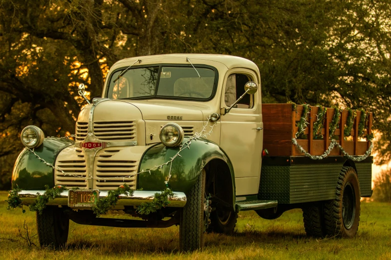 an old truck with a wood crate on the front sits in a field