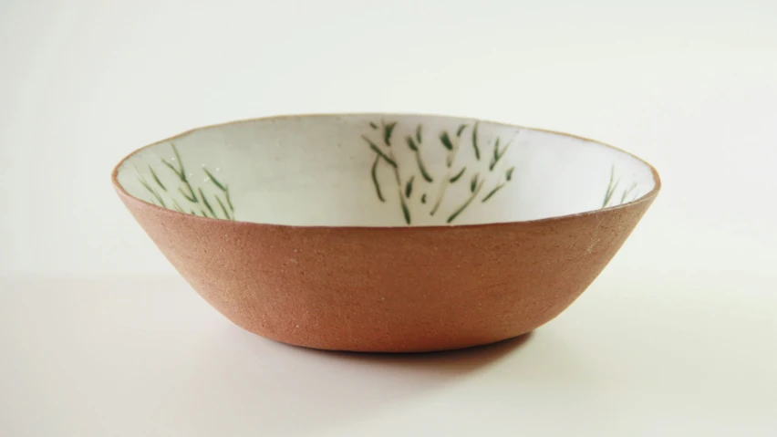 a small brown and white bowl with a design on the side