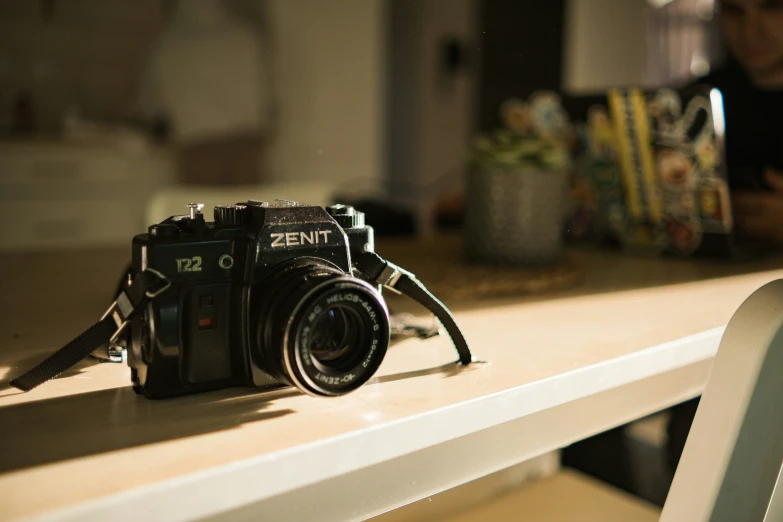 a camera sitting on a white table by a person