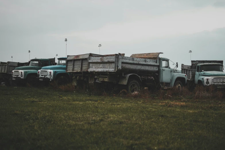 several old trucks are sitting in a grassy area