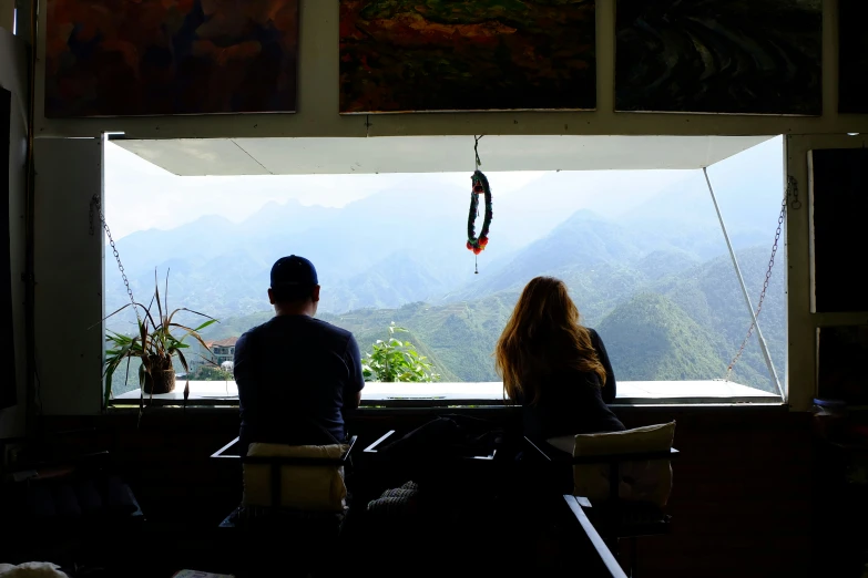 two people sitting on chairs with mountains in the background