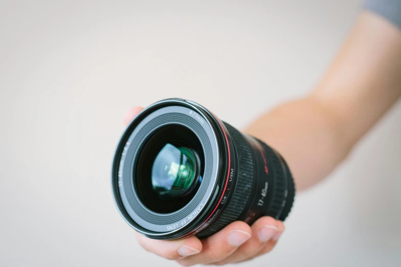 the person holding the lens is holding in their hand