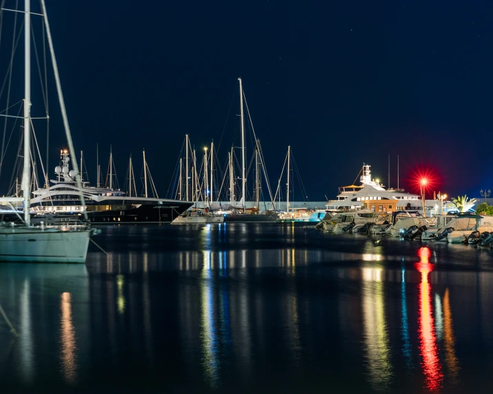 sailboats are moored on the shore in the evening