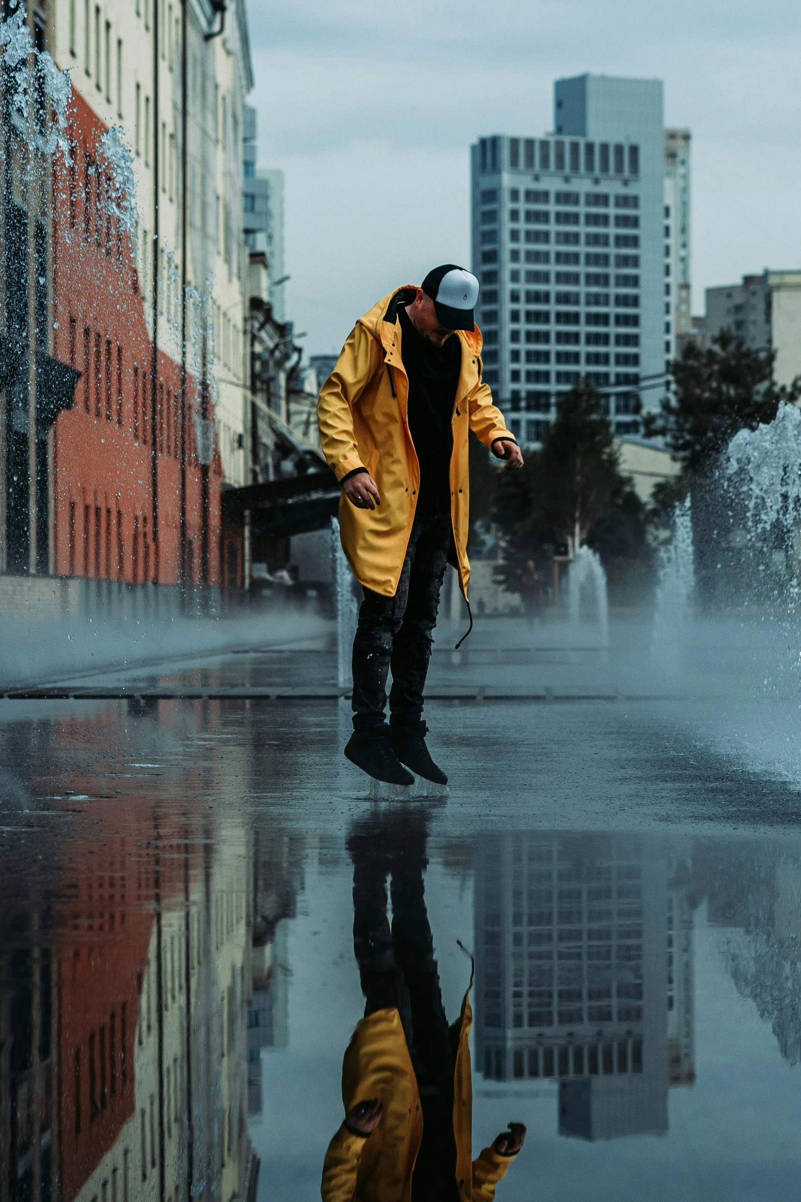 the reflection of a man in the water while a fire hydrant spews out some water