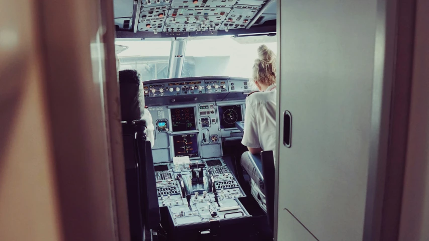 a woman standing on top of an airplane above the cockpit