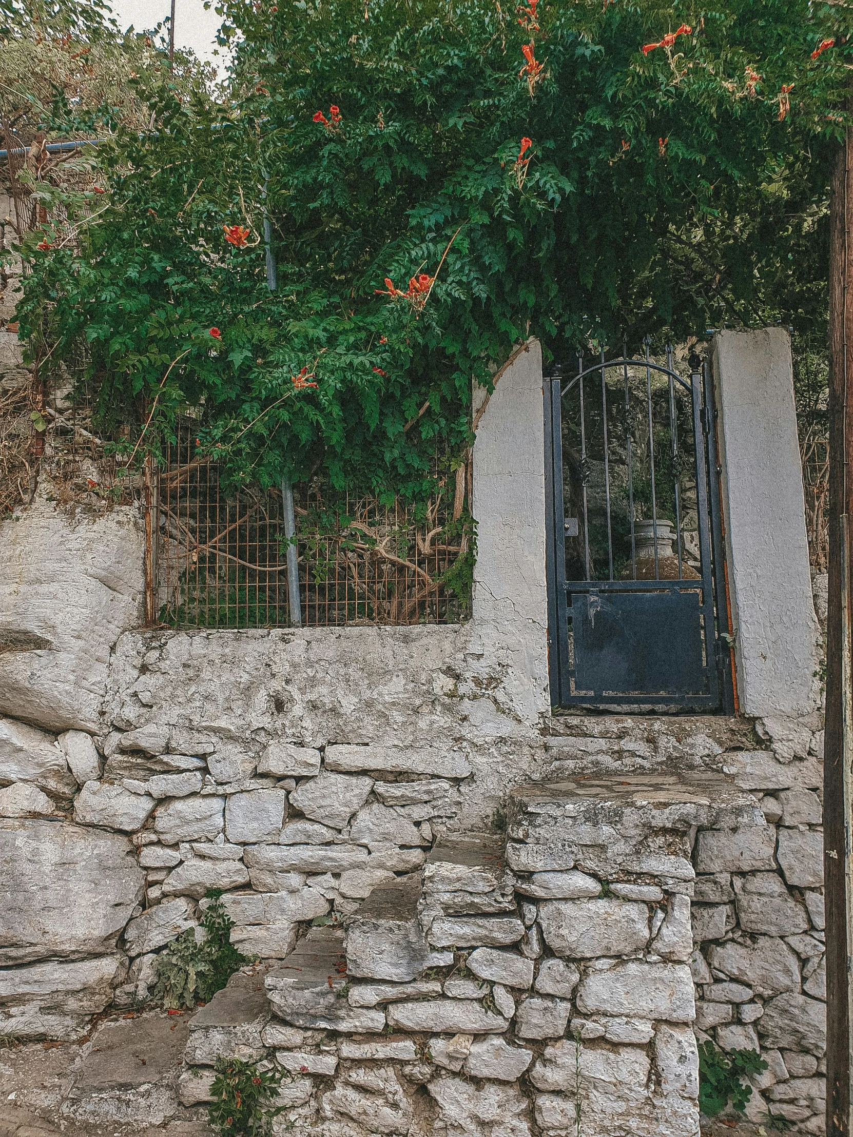 a small wall with an open window that is next to a fence