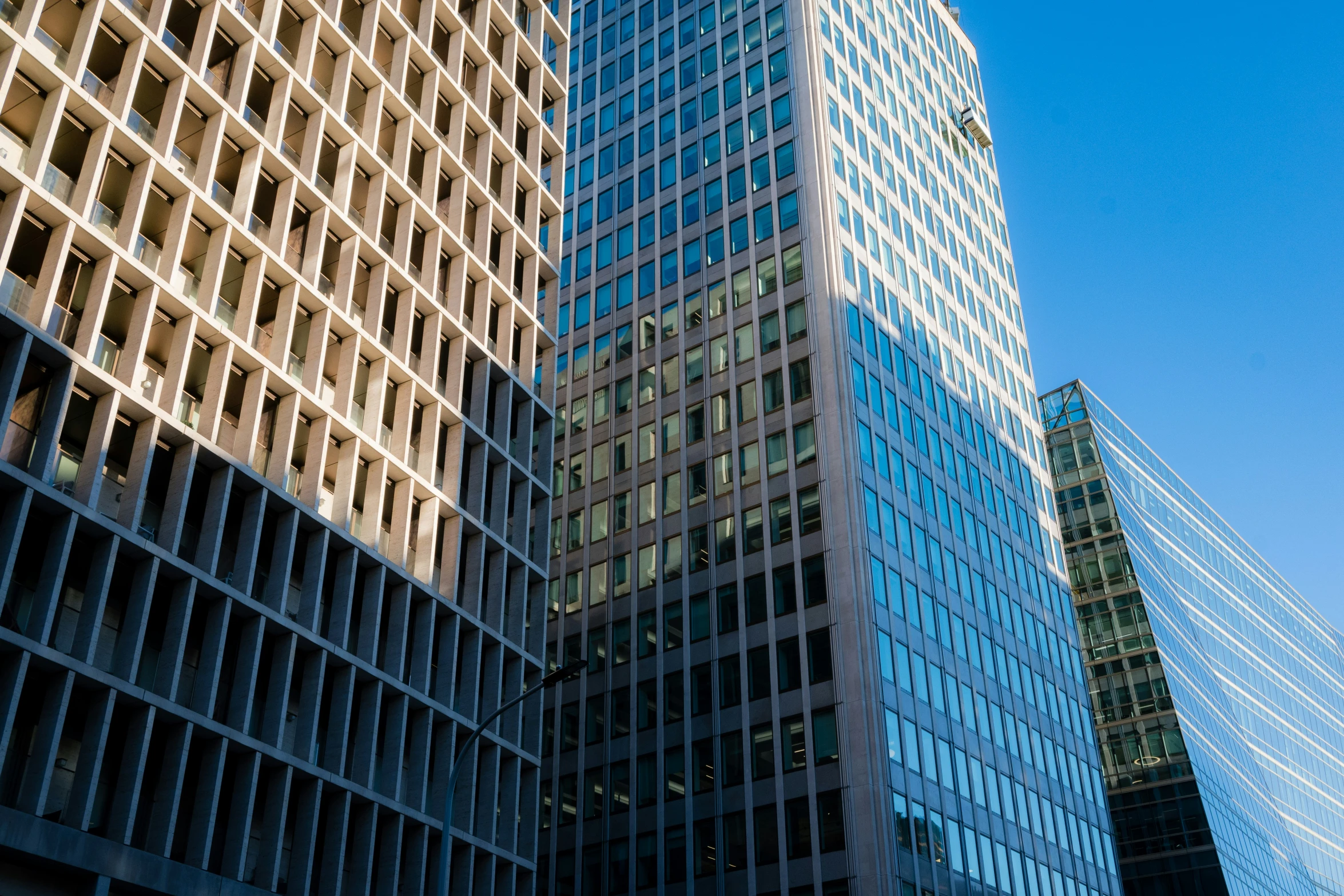 two very tall buildings towering over another building