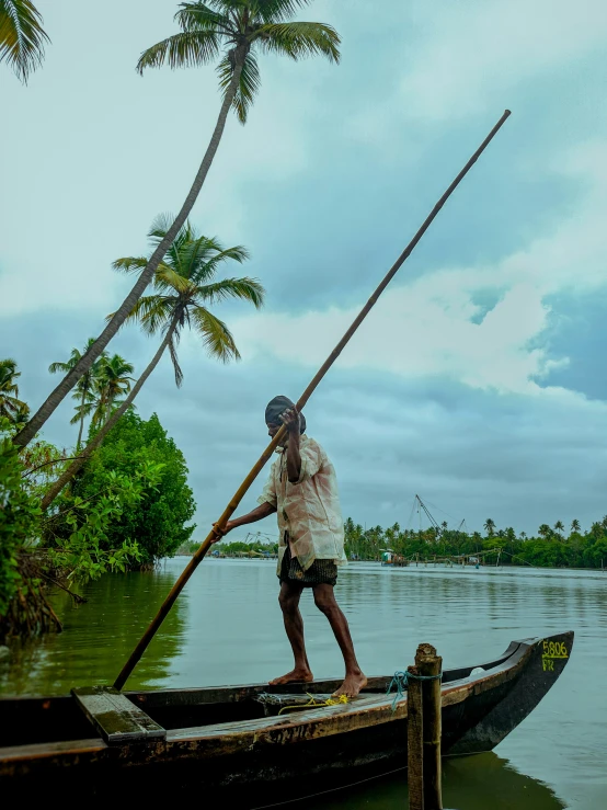 a man standing on the end of a boat in the water