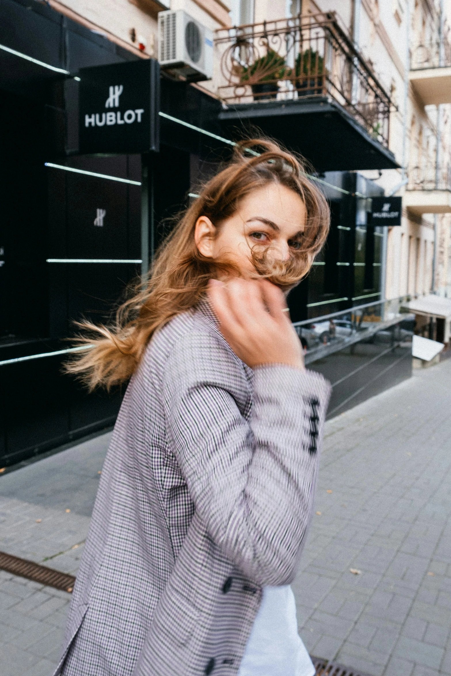 woman holding up her nose in front of a bulot store