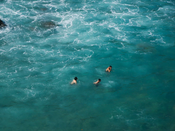 three people are in a lake that is blue