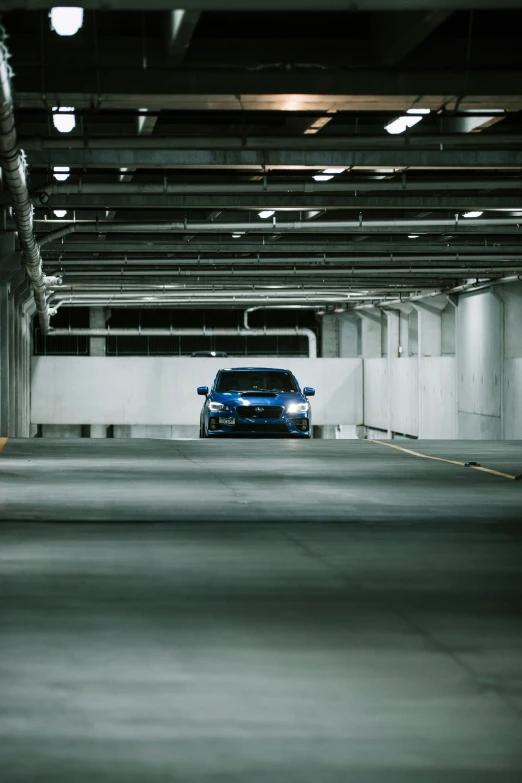 blue car parked in large parking garage area