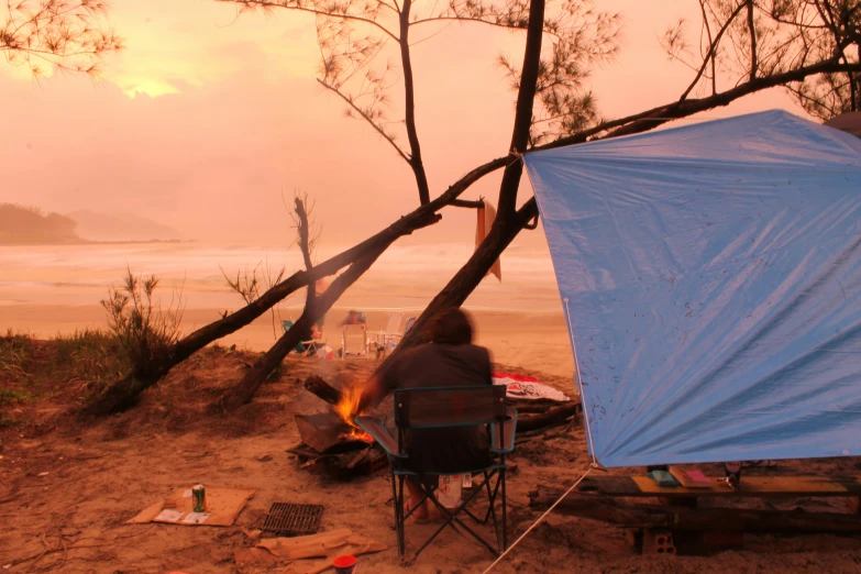 a person is camping in a tent on a beach