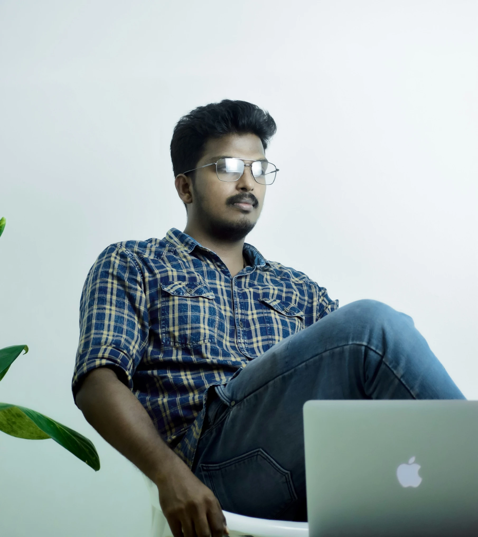 a man sitting on top of a table near a laptop