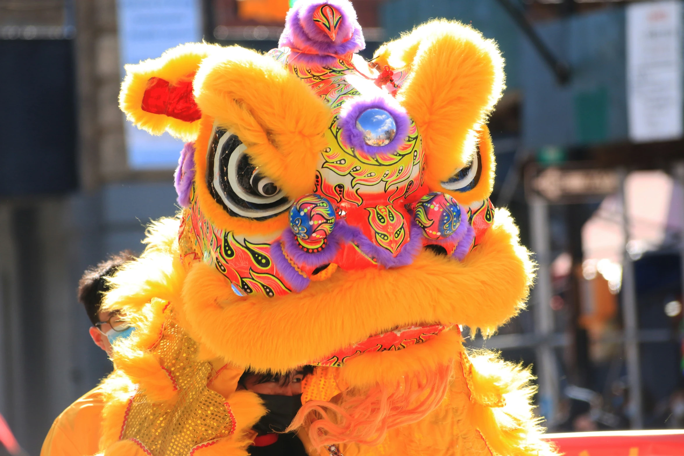 a person dressed in yellow and purple is wearing a dragon costume