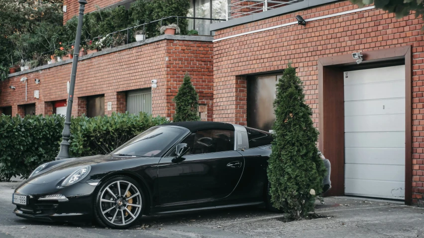 a black sports car parked outside of a brick building