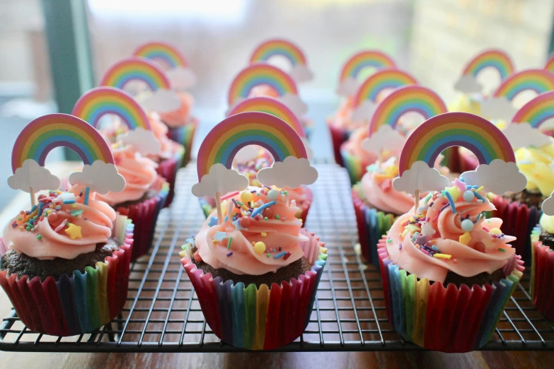 some cupcakes with icing on a rack with decorations