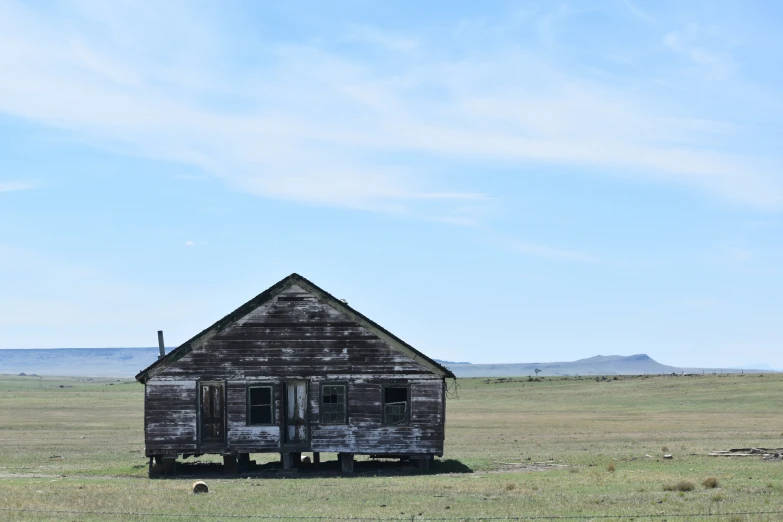 an old barn stands in an empty field