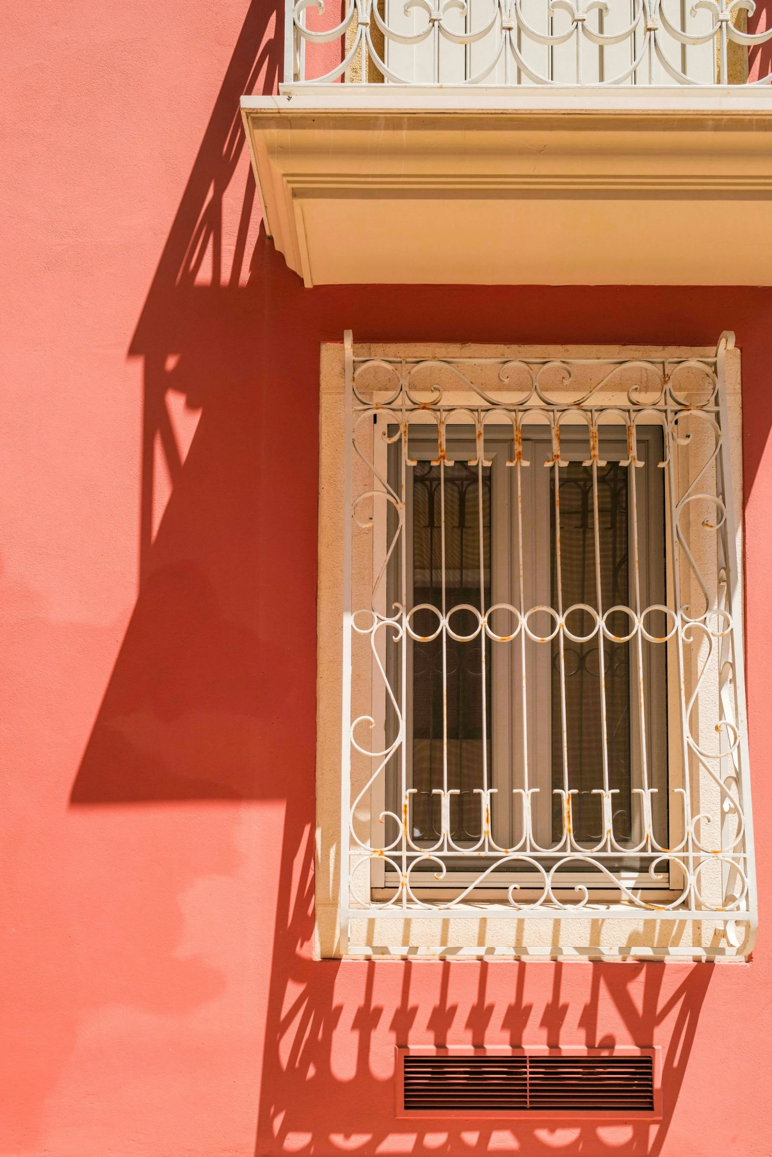 the window has metal bars and a rod is in front of it