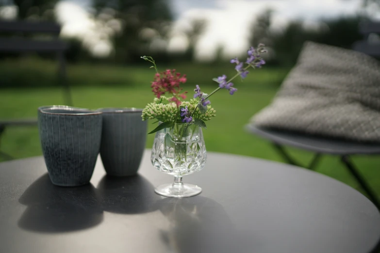 vases and flower arrangements on table in outdoor setting