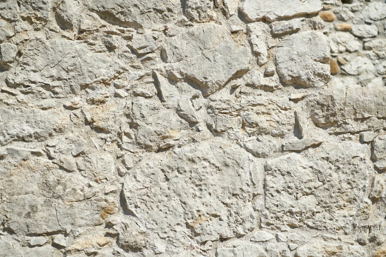 the texture of a stone wall with some brown rocks