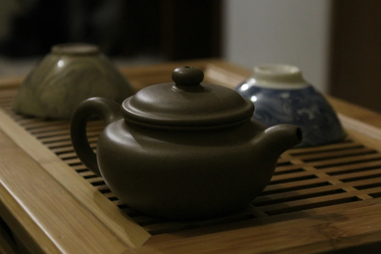 three cups that are on top of a tea pot