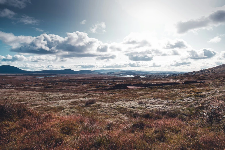 an open plain surrounded by grass and mountains