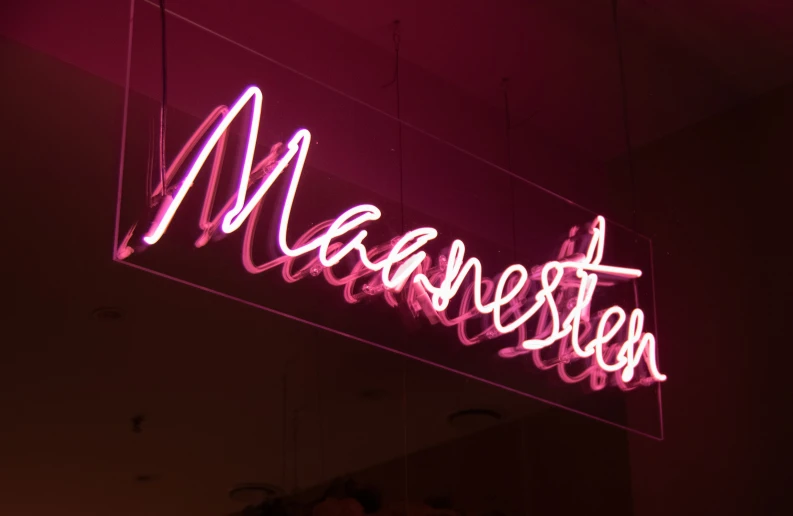 a neon sign with the word manchester underneath it