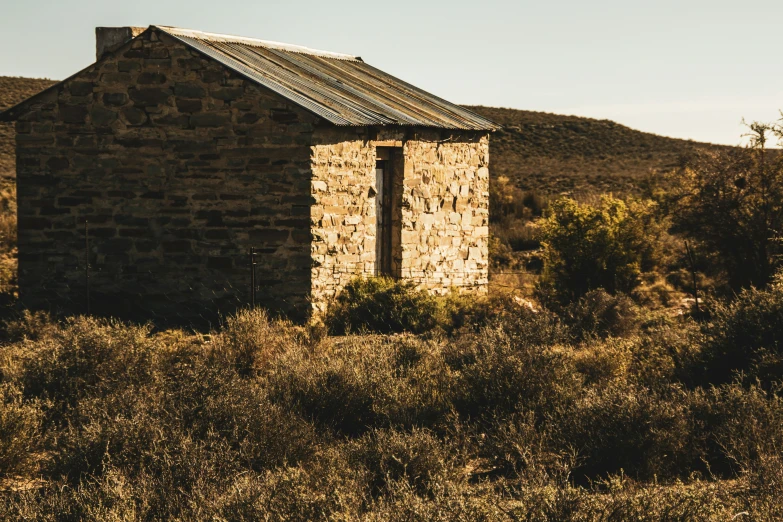 a building sits in the middle of some brush