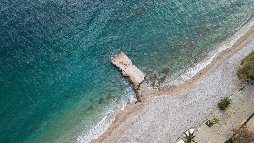 an aerial view of a sandy beach and blue ocean