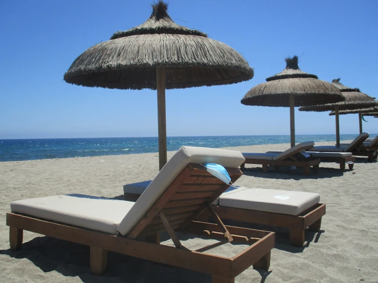 lounge chairs and straw umbrellas on a beach