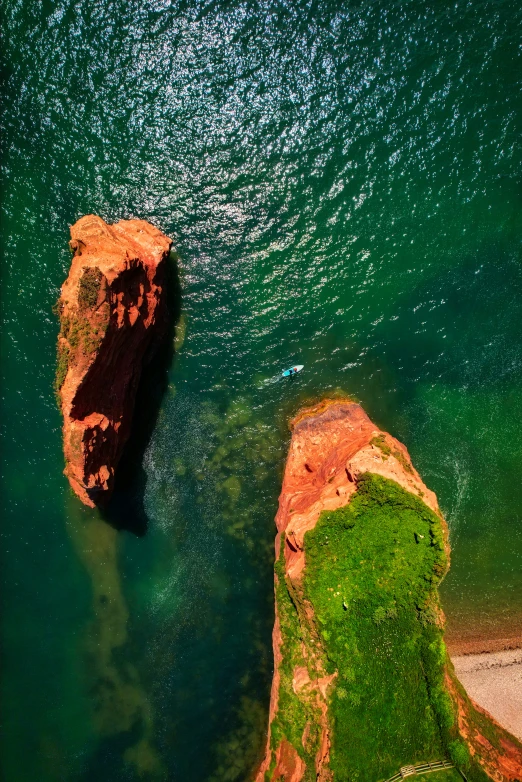 an image of two large boulders sticking out of the water