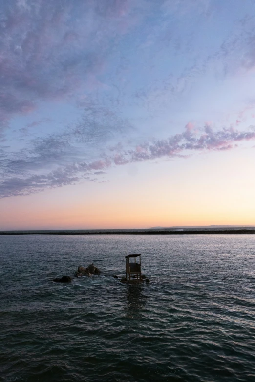 a blue and pink cloudy sky near the ocean