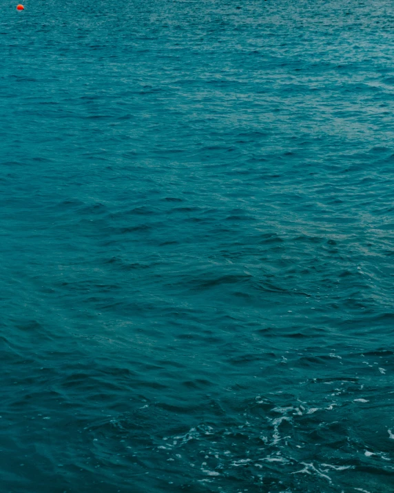 a lone boat floats through the open water