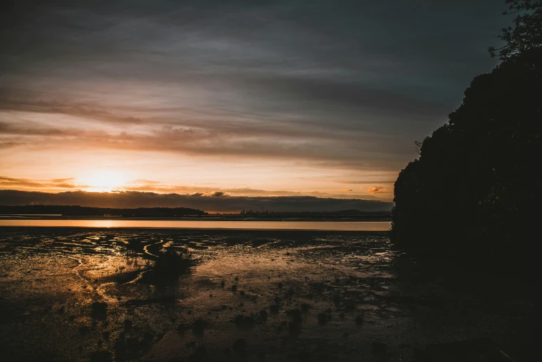 a sunset at the beach on a cloudy day