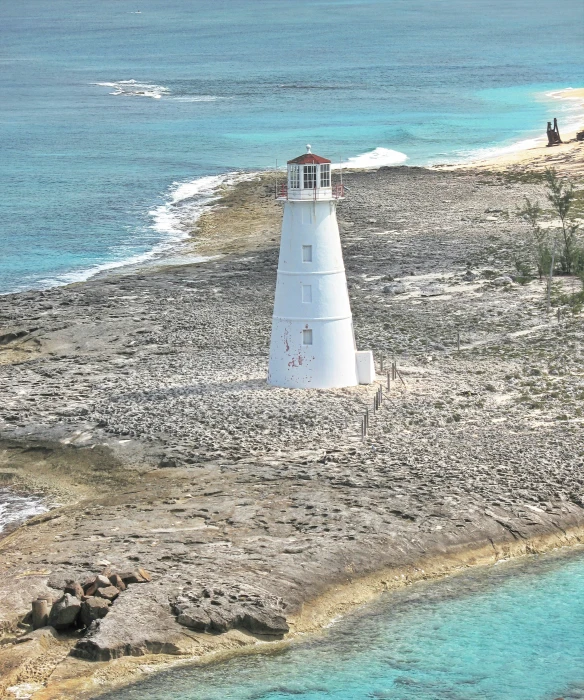 a very tall light house on top of a small beach