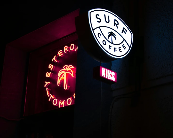 the neon sign for surf cafe is very colorful