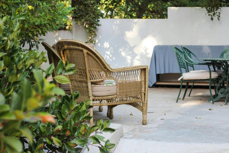 a patio with wicker furniture sitting on the concrete