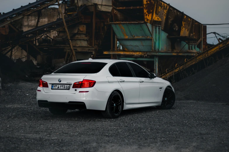 a white bmw on a gravel road