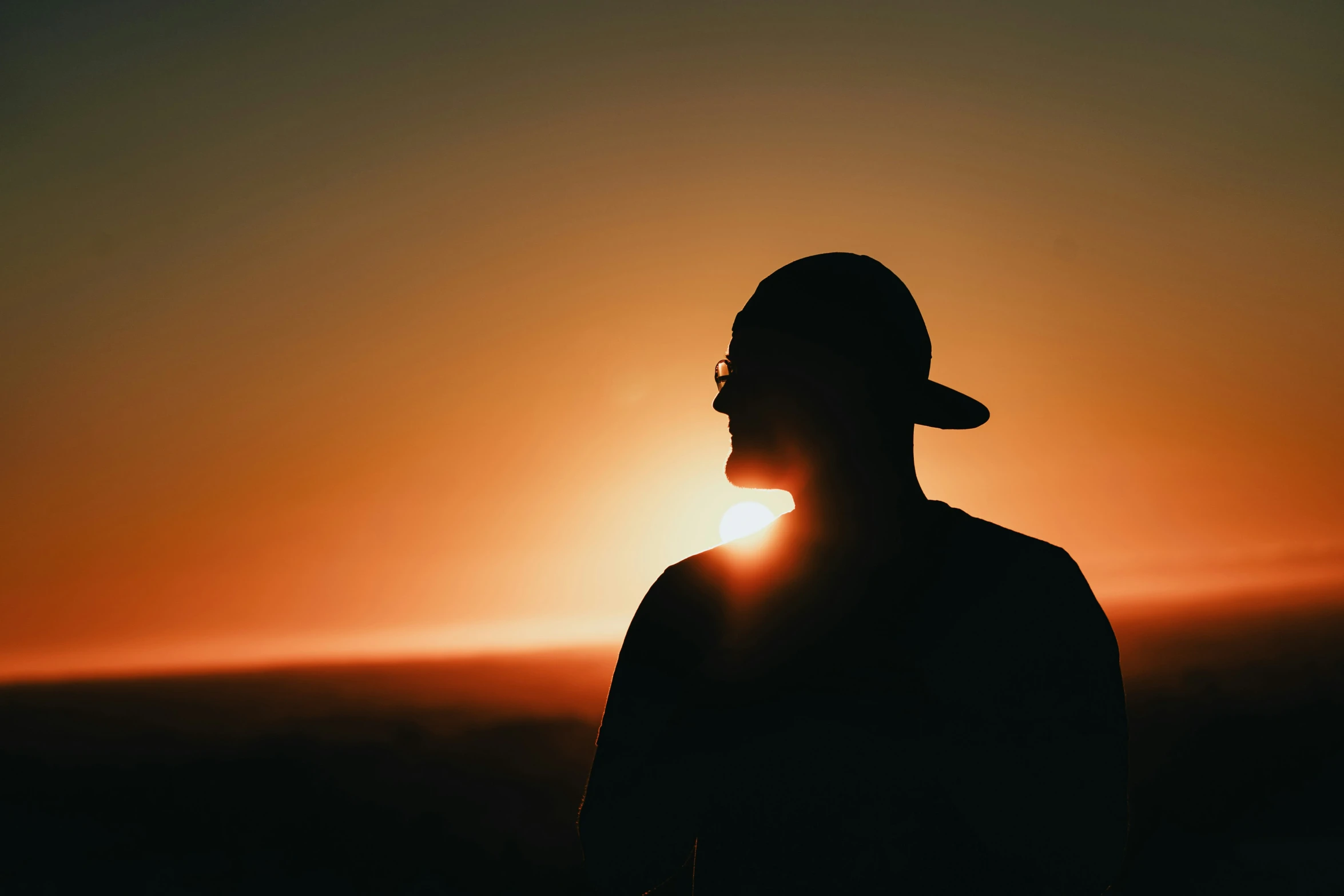 a man with his face obscured by the sun